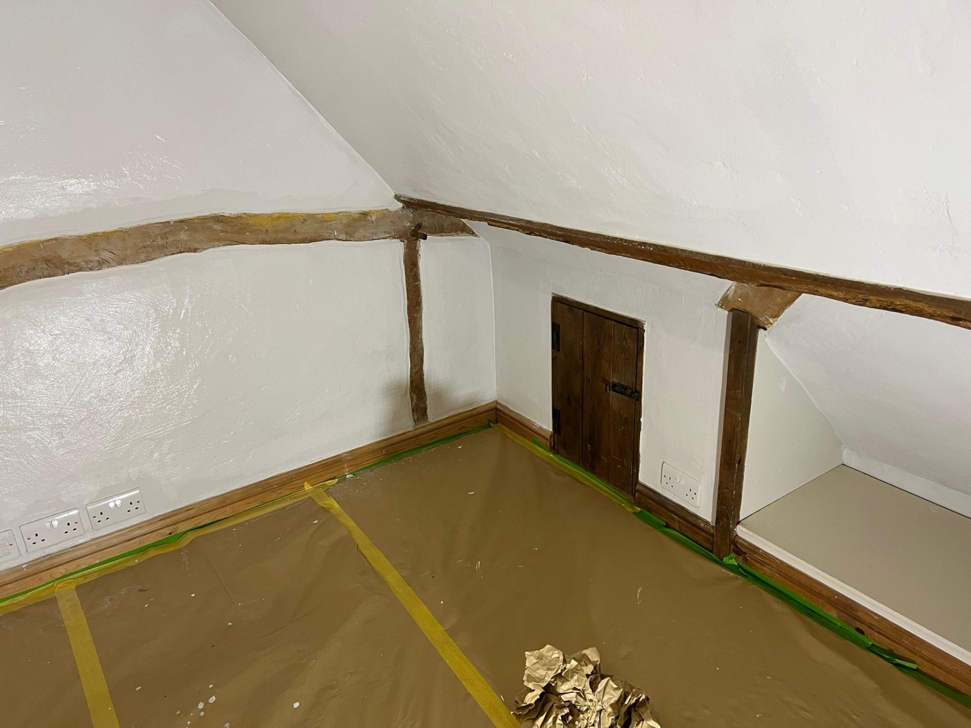 Restored period attic room with painted walls and exposed oak beams
