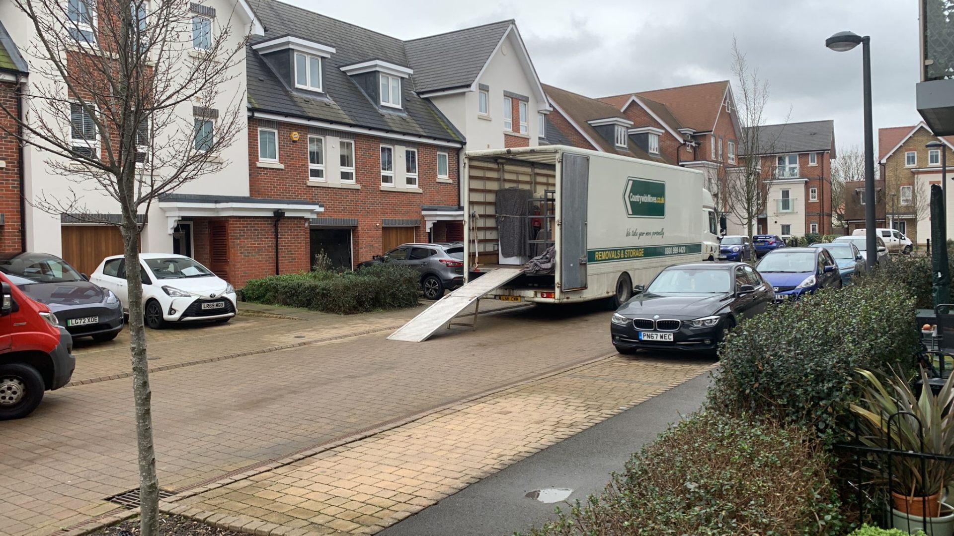 Verified UK removal crew loading a Luton van on a residential street