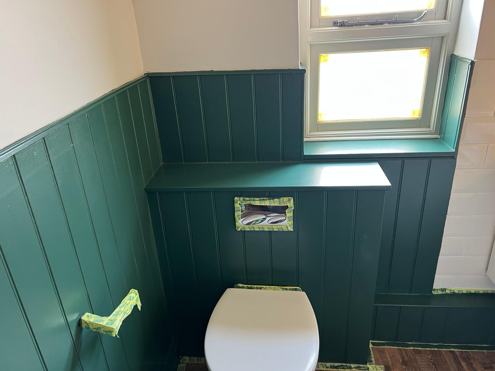 Freshly painted deep green tongue-and-groove panelling in a UK home