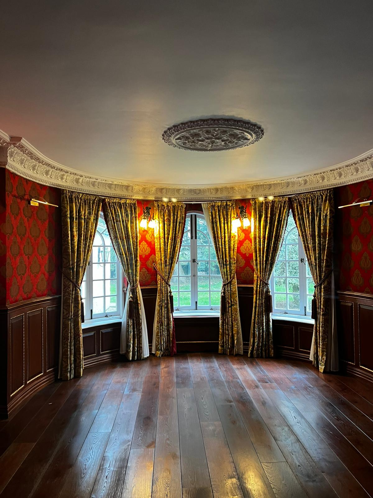 Elegant drawing room with ornate ceiling, chandelier and classic furnishings in a high-value UK residence