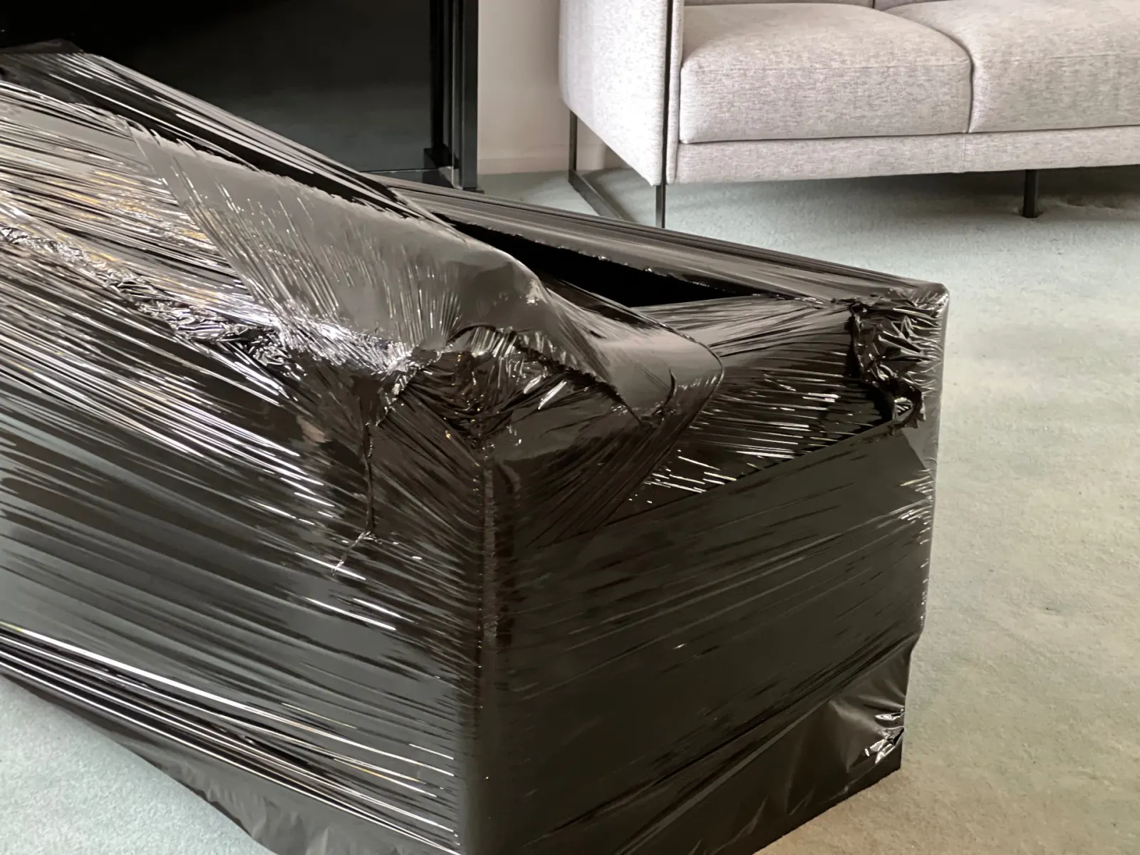 Verified MoveQuoteLocal partner professionally shrink-wrapping a sofa on a real UK house move